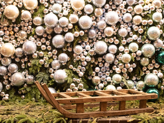 big empty sleigh with huge shiny glass decorative silver color balls covered entire wall on background