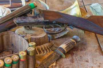 Beautiful hunting gun and equipment on old wooden background