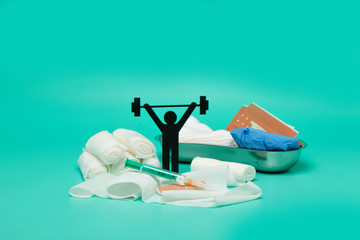 Weight lifting pictogram, plaster bandage roll and scissors