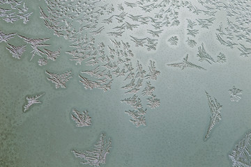 Winter motif on glass of frozen drops. A lovely background of frozen drops of water on the glass. Window glass with cold foggy condensation abstract closeup background 