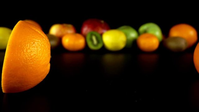 Falling of oranges against the background of fruit. Slow motion.
