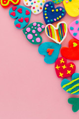 Fototapeta na wymiar Colorful handmade plasticine hearts on pink background with copy space
