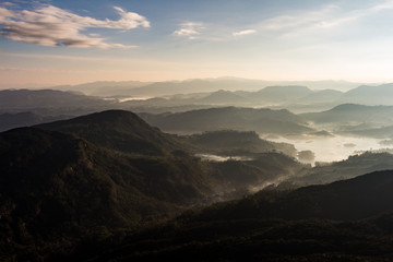 View over mountain from a mountain peak. Panorama view over mountains and lake. Misty morning just after sunrise. Nature landscape.