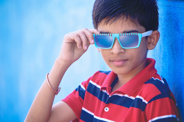 Attractive Indian young boy model posing to camera with glasses