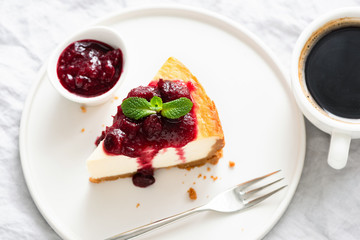 Slice Of Cheesecake With Cherry Sauce And Cup Of Coffee. Table top view