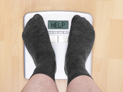 overweight man on personal scales, display reads help