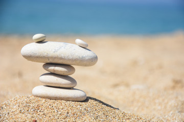 Balanced stone pyramid on sand on beach. Zen rock, concept of balance and harmony