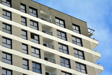 Fototapeta premium New block of modern apartments with balconies and blue sky in the background