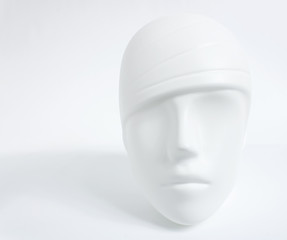 White plastic human head from mannequin as soft object with shadows, shades of gray, mild style concept, on white