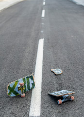 Broken skateboard on dark asphalt street © Degimages