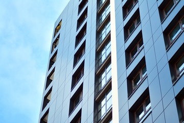 New block of modern apartments with balconies and blue sky in the background