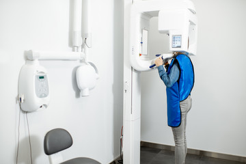 Modern cental x-ray rom with woman making panoramic shot of the jaw