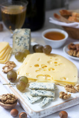 Appetizers of various types of cheese, grapes, nuts and honey, served with white and red wine. Rustic style.