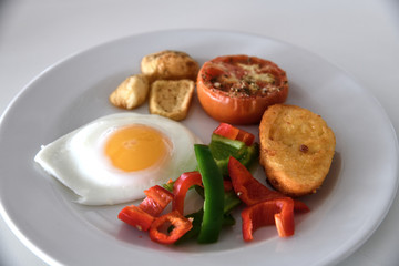 Breakfast with scrambled eggs, fried buns and vegetables