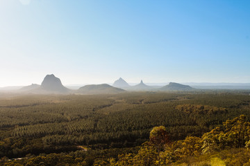 Fototapeta premium Panorama of Glass House Mountains with fog covering the picturesque mountains during daytime (Brisbane area, Queensland, Australia)