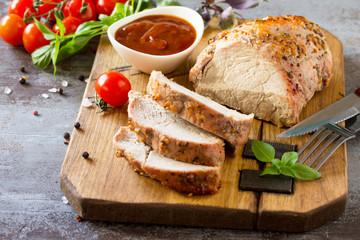 Baked Meat. Roast pork Meat with honey-mustard glaze served with ketchup on a dark stone table.