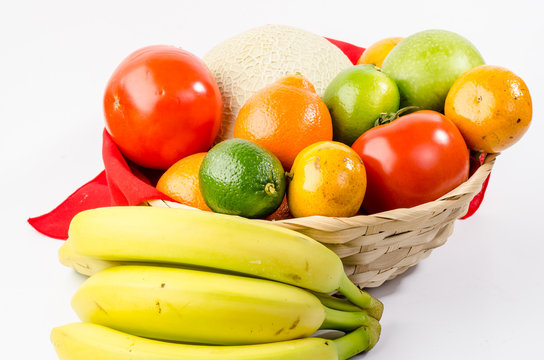 Wicker Basket Filled With Variety Of Fruit Against White BG