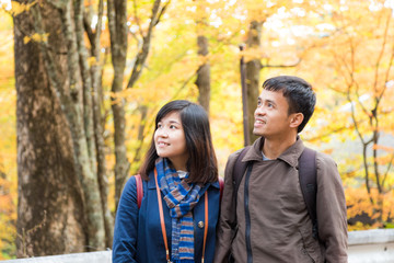 Fototapeta premium Asian couple of love enjoying autumn season colorful tree leaf
