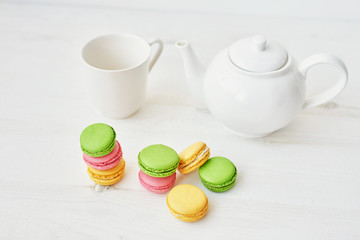Macaroons and tea set. Traditional french macarons with tea set on the background. Spring and Easter holiday concept with copy space. Template Easter Greeting Card.