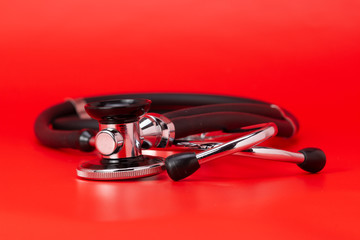 Stethoscope, close-up, red background
