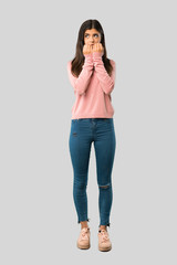 Full body of Teenager girl with pink shirt is a little bit nervous and scared putting hands to...