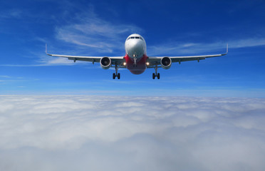 View of the airplane with full landing configuration flying over the beautiful cloud. Seen in front...