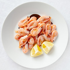 shrimps boiled with black pepper and bay leaf served with lemon