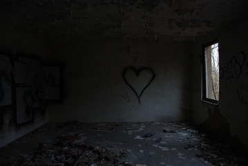 Urbex, scary abandoned and dark room with black heart on the wall