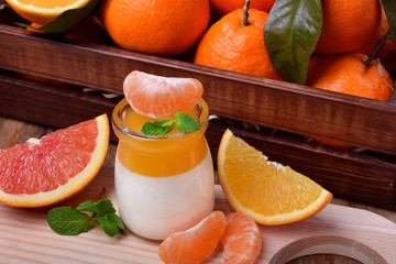 Creamy panna cotta and orange citrus jelly. Two layered dessert surrounded by fruits