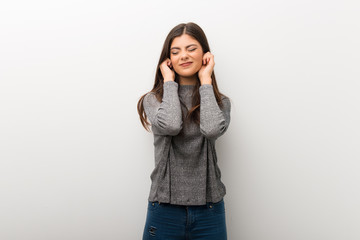 Teenager girl on isolated white backgorund covering ears with hands. Frustrated expression