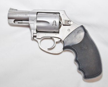 A stainless steel 357 magnum revolver with a black handle on a white background