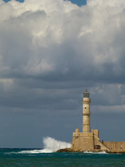 Fototapeta premium White waves with a lot of spray are beating on the lighthouse in Chania under a gloomy sky