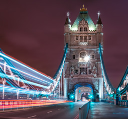 Tower bridge at night with light trails left by a passing double-decker bus, London, England, United Kingdom