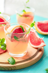 Pink alcoholic cocktail with grapefruit, ice and min