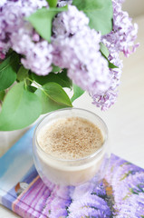 Obraz na płótnie Canvas cup of coffee and lilac flowers