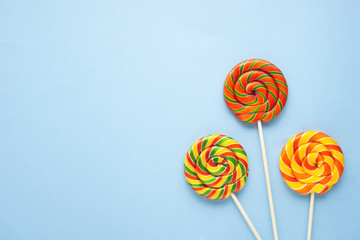 Creative concept photo of lolli pop popsicle candy on blue background.