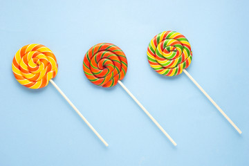 Creative concept photo of lolli pop popsicle candy on blue background.