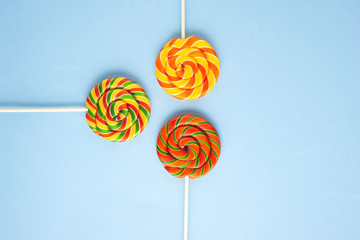 Creative concept photo of lolli pop popsicle candy on blue background.