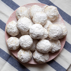 Homemade white mexican wedding cookies on pink plate, overhead view. Top view, from above. Close-up.