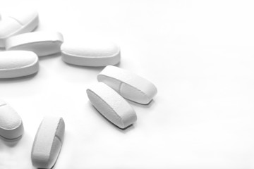 white medical pills, on white background, close-up