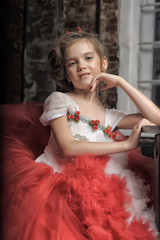 young princess in a red and white dress sitting