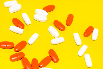 colorful medical pills, on yellow background, closeup