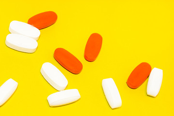 colorful medical pills, on yellow background, closeup