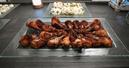 Roasted spicy chicken wings on a glass tray.