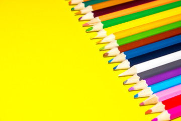 School supplies, colored pencils in a row, isolated, closeup
