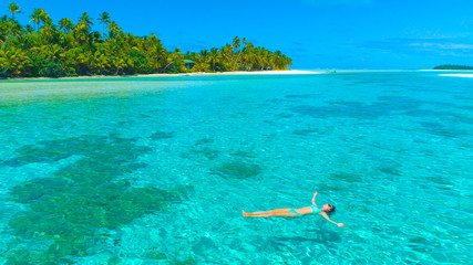 DRONE: Relaxed female traveler enjoying her vacation on scenic One Foot Island.