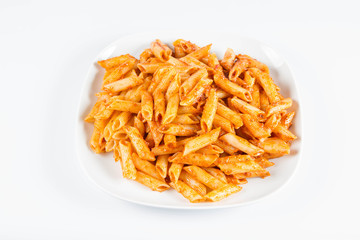 Penne with pesto on a plate on a white background