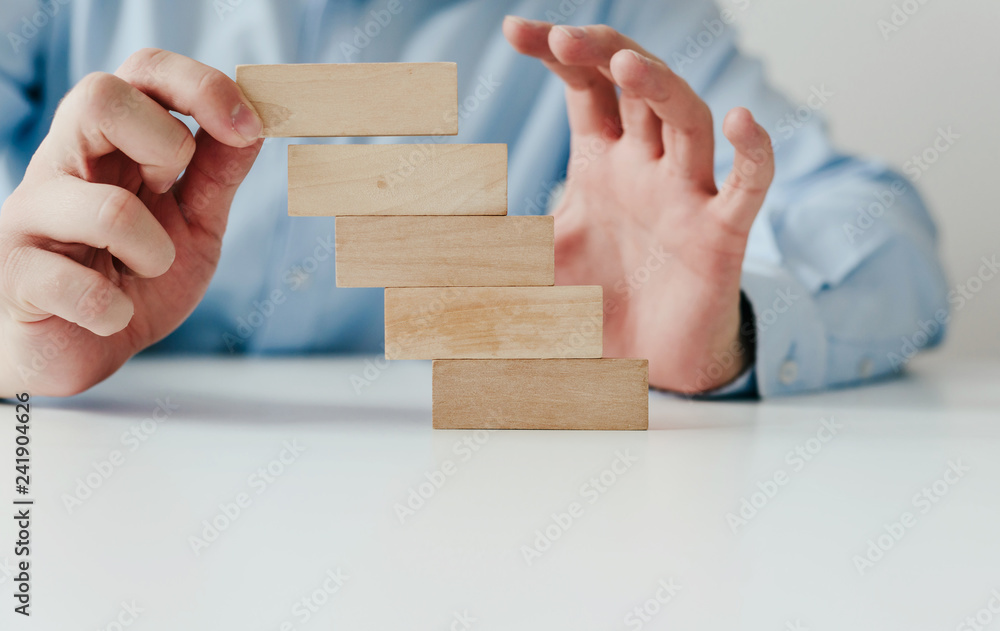 Poster hand holding a wooden jigsaw puzzle with blank space. there is a matching puzzle next to it. the con