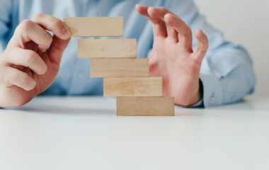 Hand holding a wooden jigsaw puzzle with blank space. There is a matching puzzle next to it. The concept of solving problems, all problems can be solved, connection.