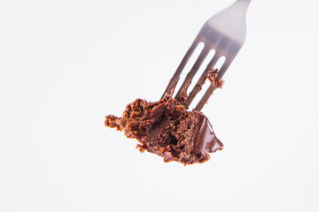Chocolate cake eaten with a fork on a white background